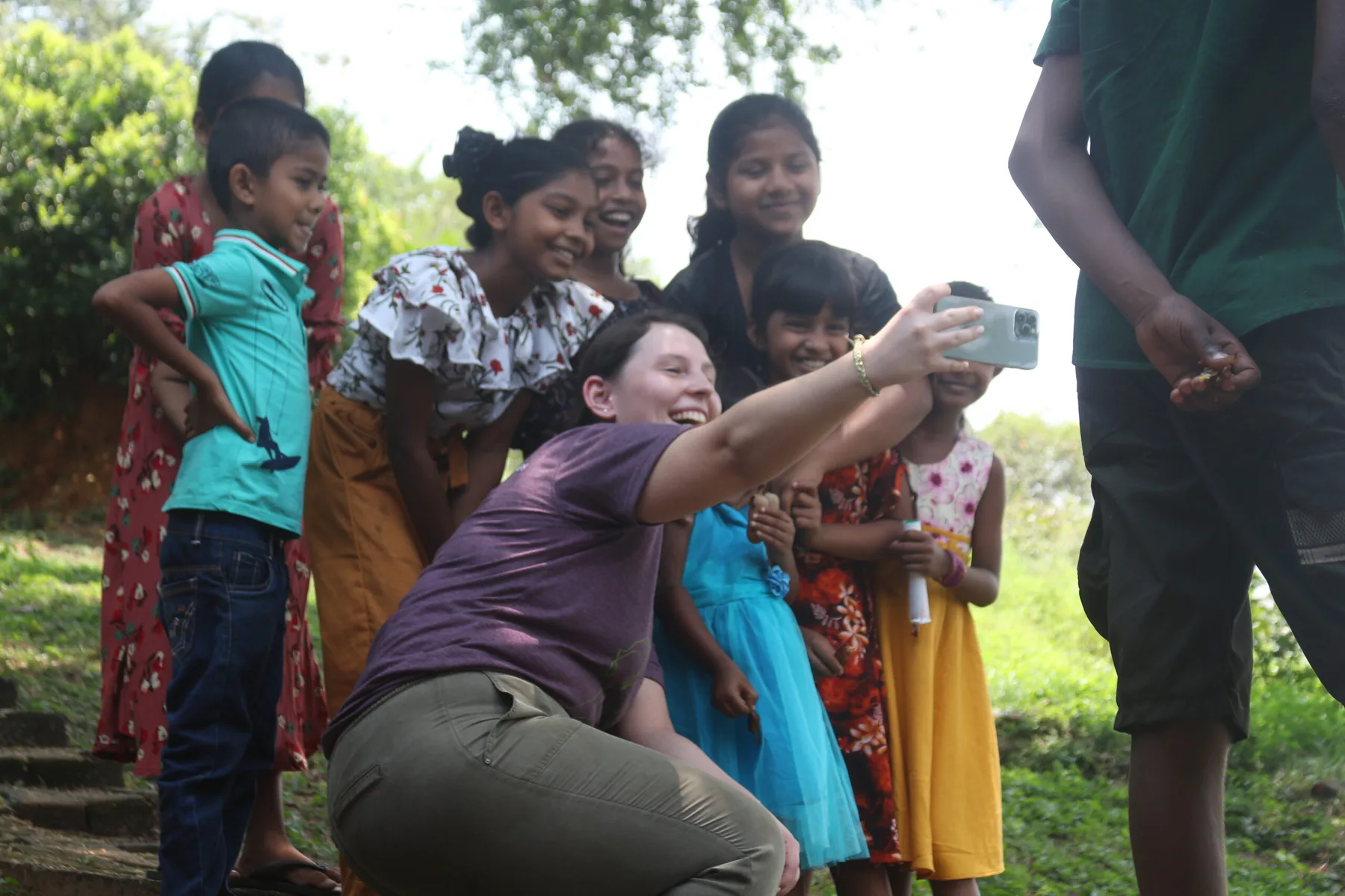 A volunteer taking a selfie with smiling village children